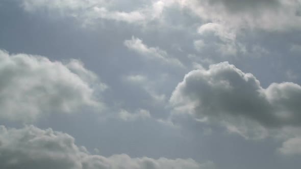 Time lapse of clouds over rural landscape with green hills