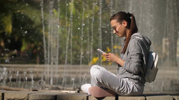 Woman Typing Text Message on Smart Phone on Nature