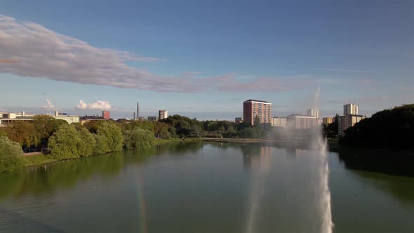 Drone flying backwards close to fountain, rainbow spotted. Malmö, Sweden