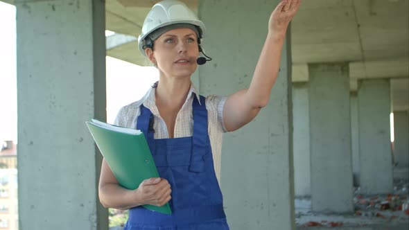 Builder Supervisor Oversees Building Site and Gives Instructions To Workers Over the Intercom