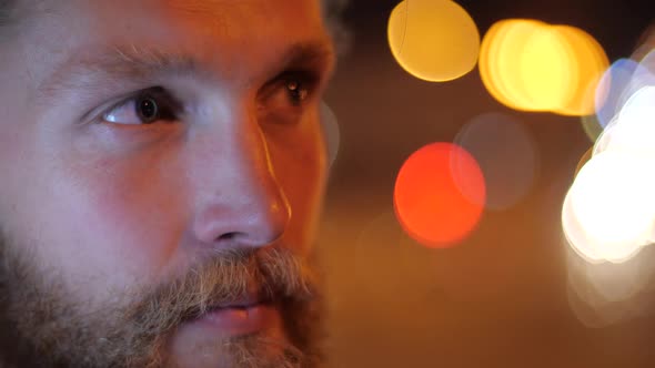 Close Up Portrait of Handsome Caucasian Bearded Long-haired Young Man with Blue Eyes Looks Away Into