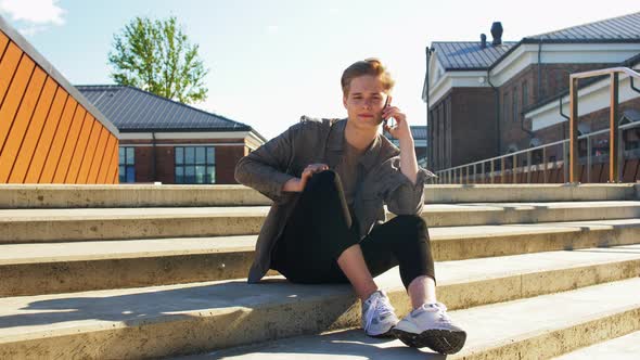 Young Man Calling on Smartphone on Roof Top