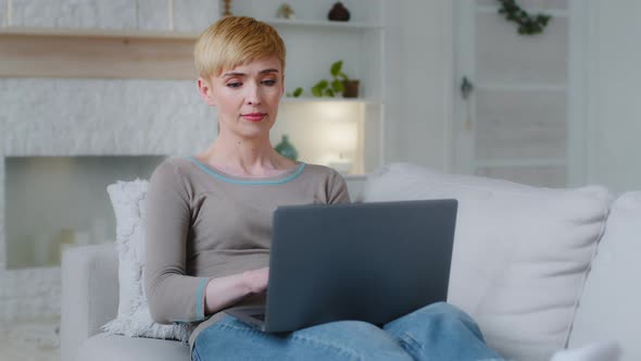Tired Young Woman Sit on Cozy Sofa in Living Room Closes Laptop After Long Usage