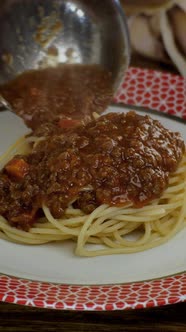 Bolognese Sauce Putting in Cooked Spaghetti or Tagliatelle Pasta in White Plate