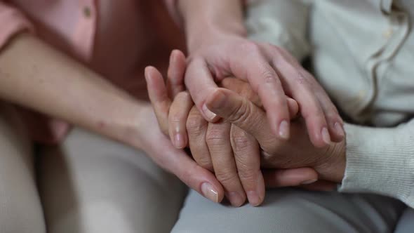 Woman Covering Mother Hands Closeup, Nursing Home Support, Family Love, Help