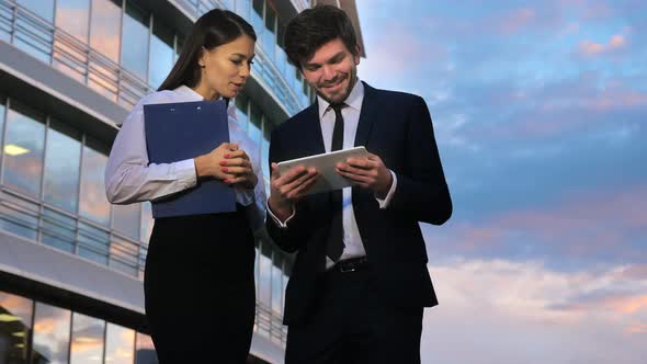 Business Couple Looking at Business Results on Digital Tablet