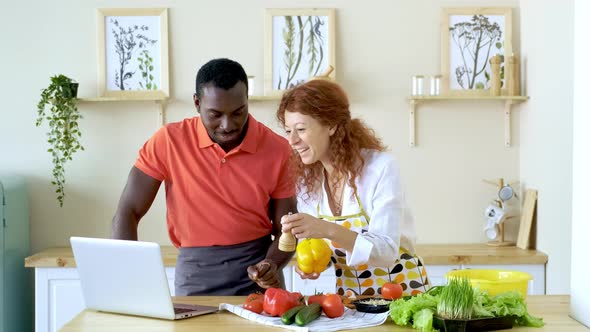 African American Couple Having Fun with Laptop in Kitchen
