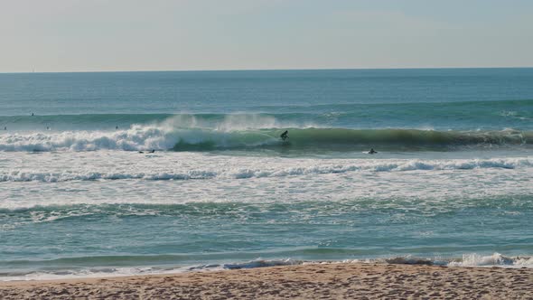 Surfer riding on blue Atlantic Ocean waves on a beautiful sunny day