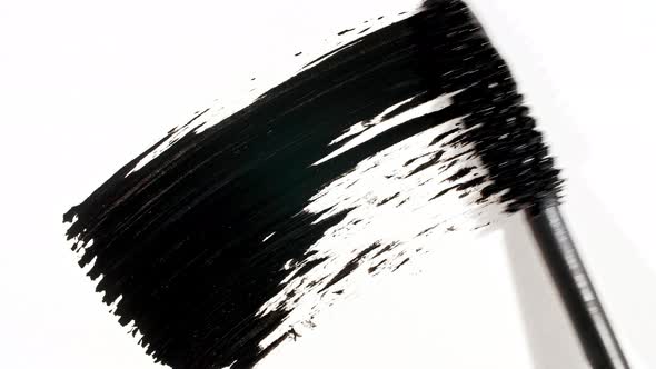 Macro Shot and Slow Motion of a Black Mascara Isolated on White Background