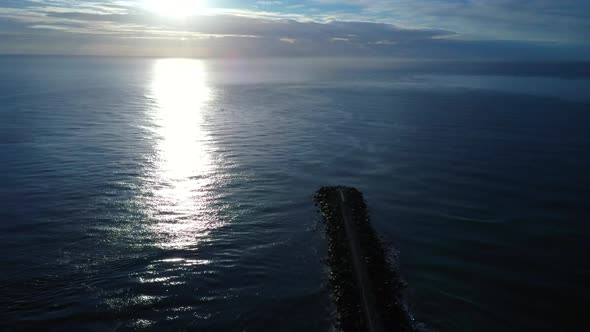 Sunrise at the Gold Coast Seaway, sun in clouds shimmering across the water