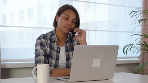 Woman Using a Laptop Working Online at Home