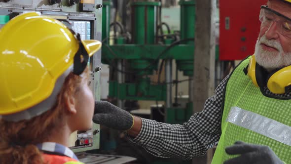 Group of Factory Workers Using Machine Equipment in Factory Workshop