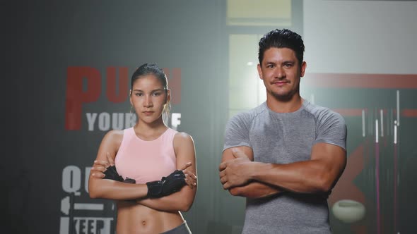 Portrait of Active athlete man and woman with six packs abs in sportswear standing and crossing arms