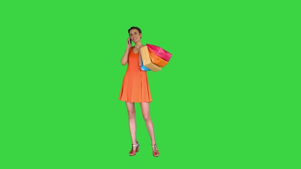 Young Woman Holding Shopping and Making a Phone Call on a Green Screen, Chroma Key