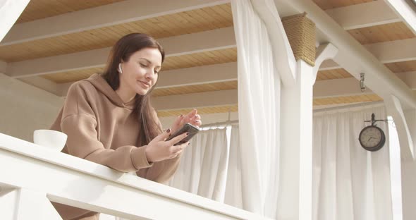 Female Listening To The Music And Drinking Coffee On A White Deck