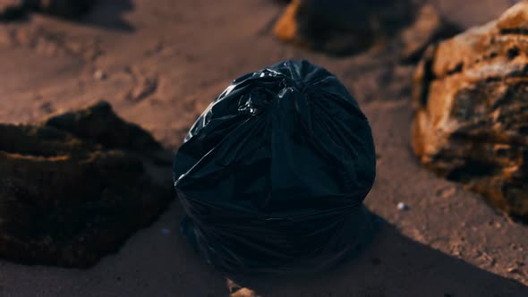 Black Plastic Garbage Bags Full of Trash on the Beach