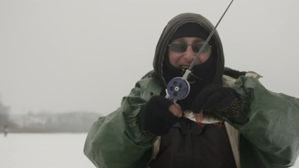 Happy man caught fish at winter fishing