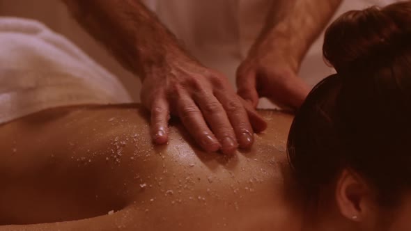 Massage Therapist Massaging Woman Lying on Table in Spa Resort in Slowmotion