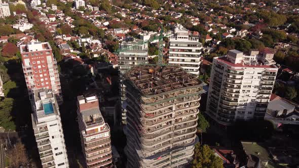 drone footage of a construction work of a skyscraper  in progress with huge crane on top of the buil