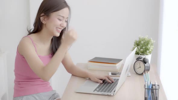 Beautiful young asian woman smile working on laptop computer with happy satisfied.