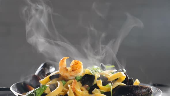 Traditional Seafood Pasta with Shrimps and Steaming in Slow Motion. Steam or Vapour Rising Up in