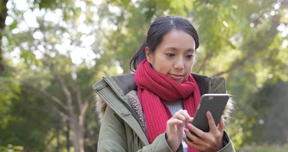 Woman use of mobile phone in citypark