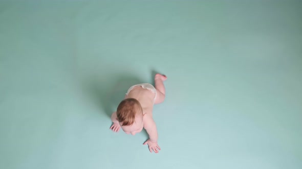 Happy toddler baby plays laughing on studio blue background