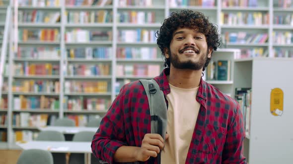 Handsome Proud Curly Indian or Arabian Male Student of University in Casual Wear with Backpack and