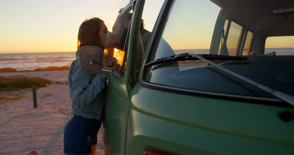 Romantic young couple kissing through van window on beach 4k