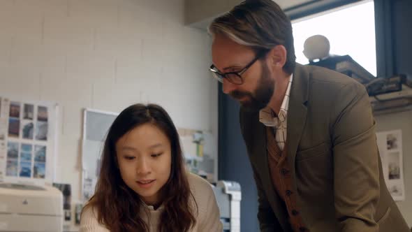 Colleagues interacting with each other at desk