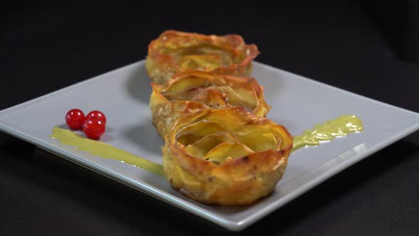 Oven-baked potato in the shape of a flower served on a plate, rotates, closeup