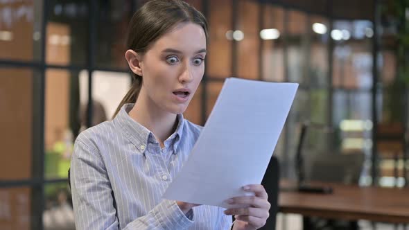 Excited Woman Celebrating After Reading Documents