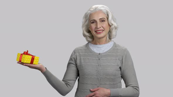 Old Retired Lady with Grey Hair Holding Gift Box