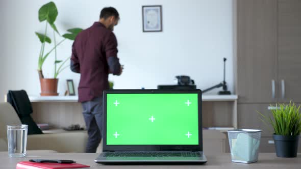 Laptop with an Isolated Chroma Green Screen on the Desk