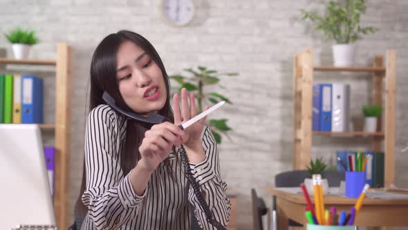 Young Asian Woman Office Worker Is Engaged in Personal Affairs at the Workplace in the Office