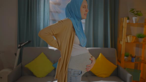 Pregnant Muslim Young Woman in a Headscarf Feels Pain and Discomfort in the Lower Back and Back
