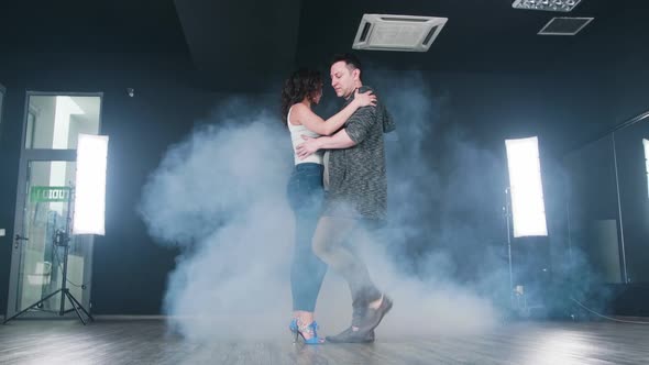 Young Couple Dancing Kizomba in Bright Led Light Panels with Smoke