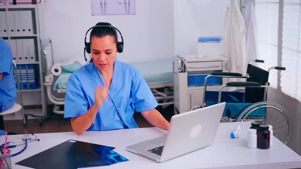 Surgeon Assistant Using Headphones in Hospital Answering to Patients Calls