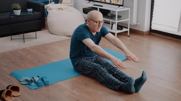 Retired Man Doing Physical Exercise to Practice Gymnastics