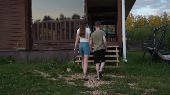 Mother with Her Son Climb the Stairs to Their Country House