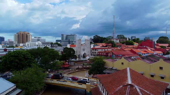 Aerial forward shot of historical malaysian buildings during dramatic clouds at sky