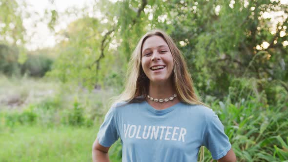 Caucasian woman smiling and looking at camera during river clean-up day