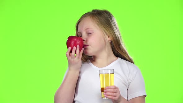 Little Girl Drinks Juice From a Glass and Holds an Apple, Green Screen, Slow Motion