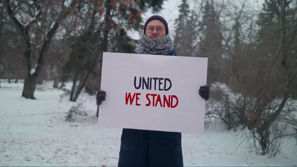 Man In Winter Park Holds Banner With United We Stand Motto Encouraging Unity