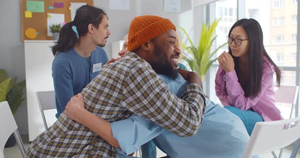 Diverse Smiling People Hugging in Support Group Meeting