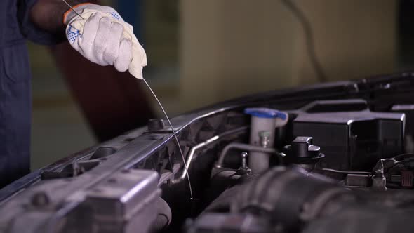 Repairman's Hands During Engine Oil Level Check