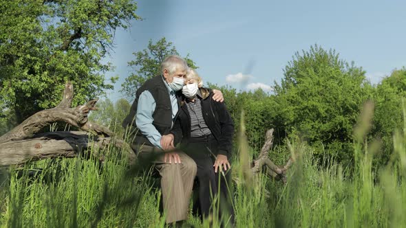 Senior Couple in Medical Masks During COVID-19 Coronavirus Quarantine in Park