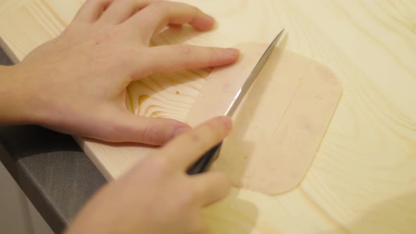 Close up of hands slicing meat strips