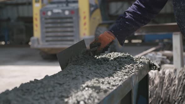 Workers pouring concrete into large steel molds on a construction site