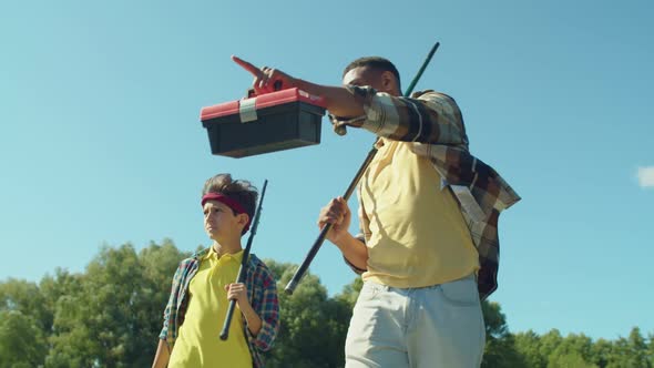 Portrait of Caring Black Father and Teenage Son with Rods Going for Angling